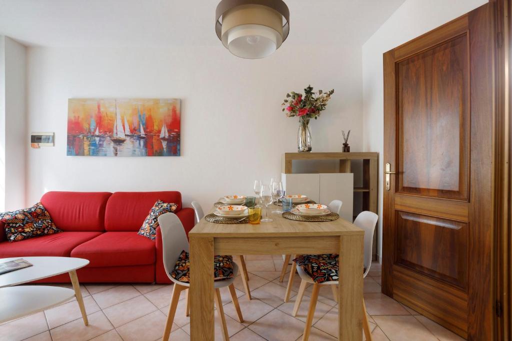 a living room with a red couch and a table at Villino Flora a Viareggio in Viareggio