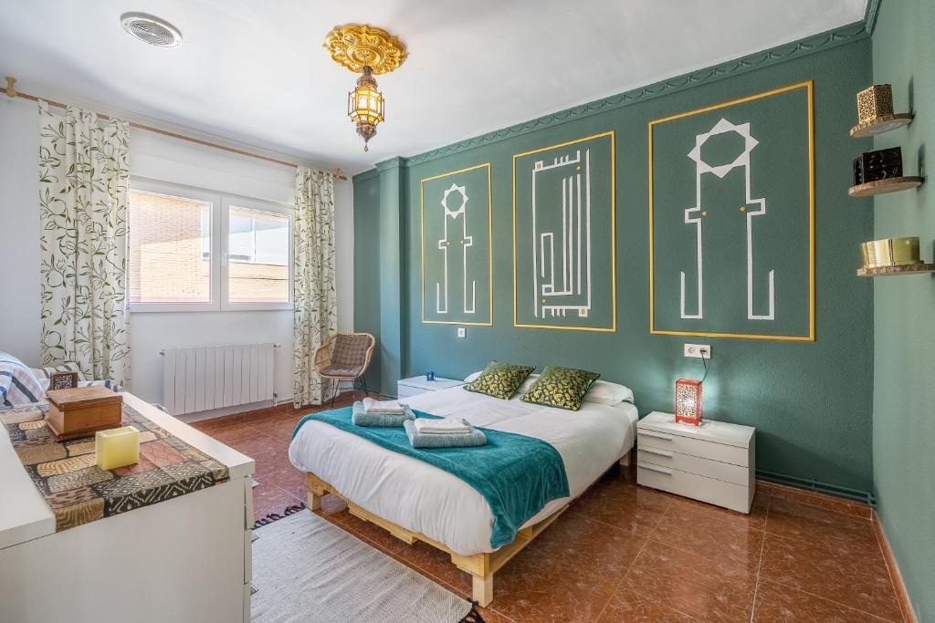 a bedroom with a bed and a green wall at Little Alhambra in Dúrcal