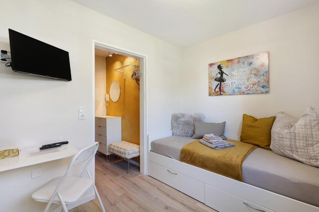 a bedroom with a bed with a desk and a tv at Mini Apartment in Bayreuth