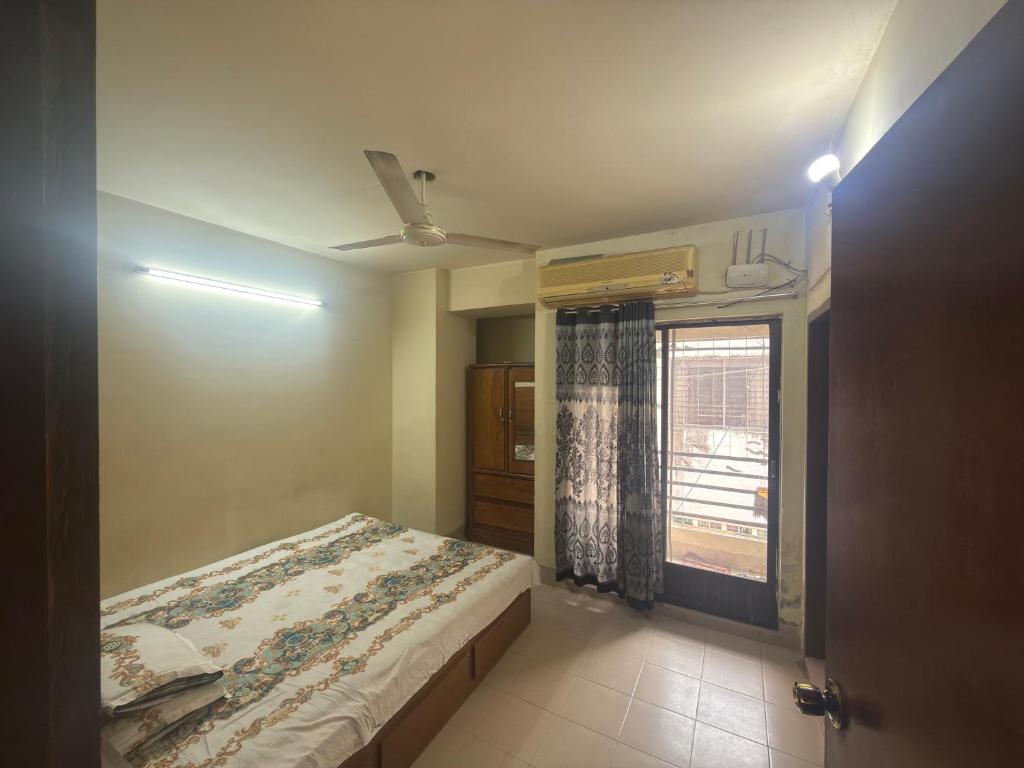 a small bedroom with a bed and a window at Garden tower,sylhet in Sylhet