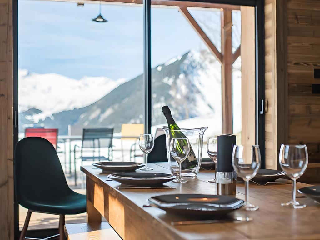 a table with glasses and a bottle of wine on it at Gite Le Mazot in Albiez-Montrond