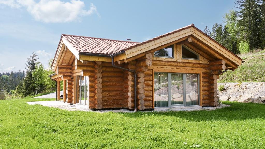 a log cabin in a field of green grass at Naturstamm Chalets in Untergriesbach