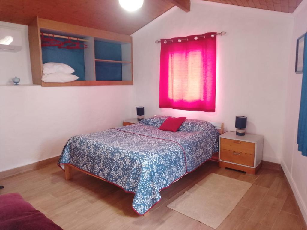 a bedroom with a bed and a red window at Nova Aurora in Lousã