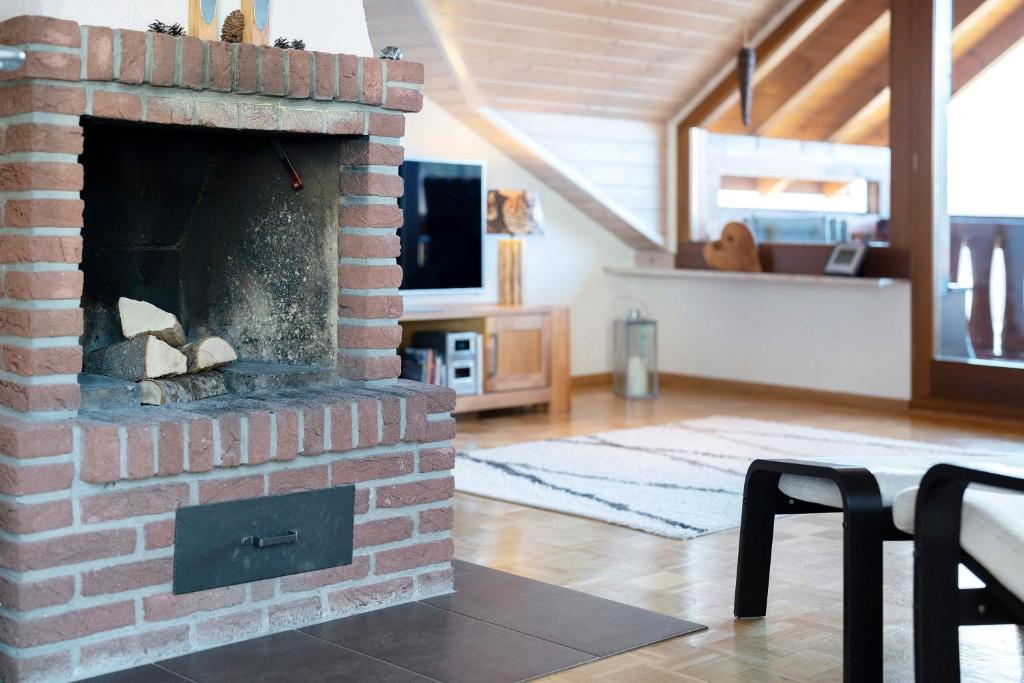 a living room with a brick fireplace with a tv at Ferienwohnung Panoramablick in Lenzkirch