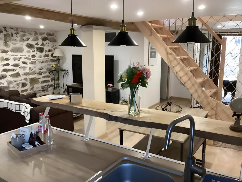 a kitchen with a large table and a staircase at Appartement de charme Saint-Romain in Saint-Romain