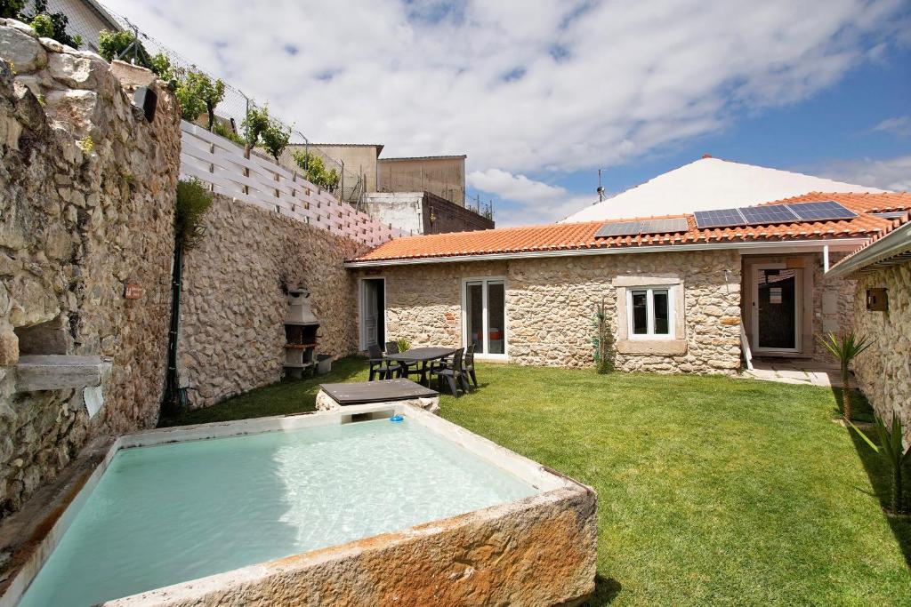 an outdoor swimming pool in a yard next to a building at Residencia Dos Castelos in Santarém