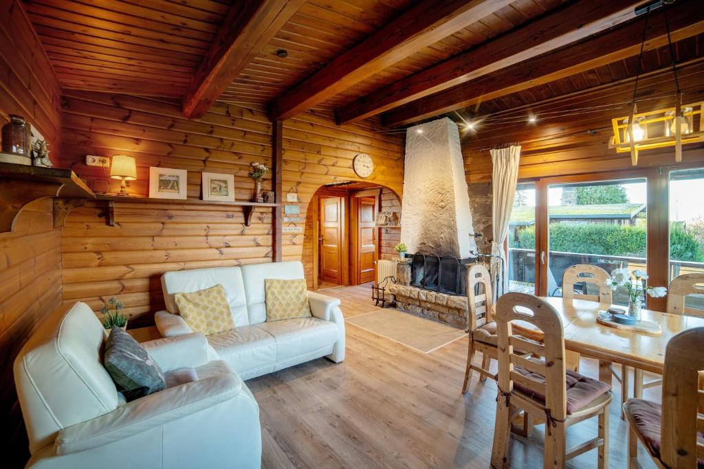a living room with a white couch and a fireplace at Chalet Bühberg Alm in Bad Lauterberg