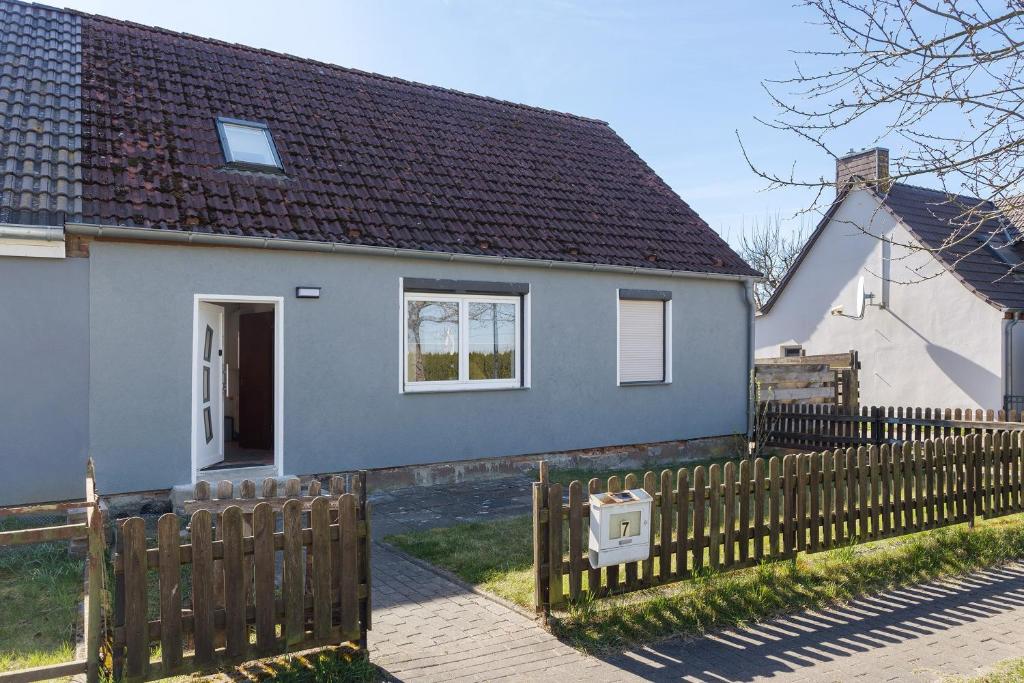 a gray house with a wooden fence at Ferienhaus in Zernitz