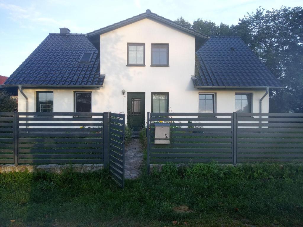 una casa bianca con una recinzione davanti di Beier a Neustrelitz