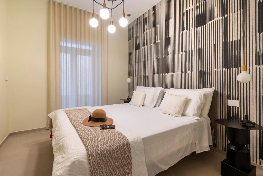 a bedroom with a bed with a hat on it at Dimora Màufra in Locorotondo