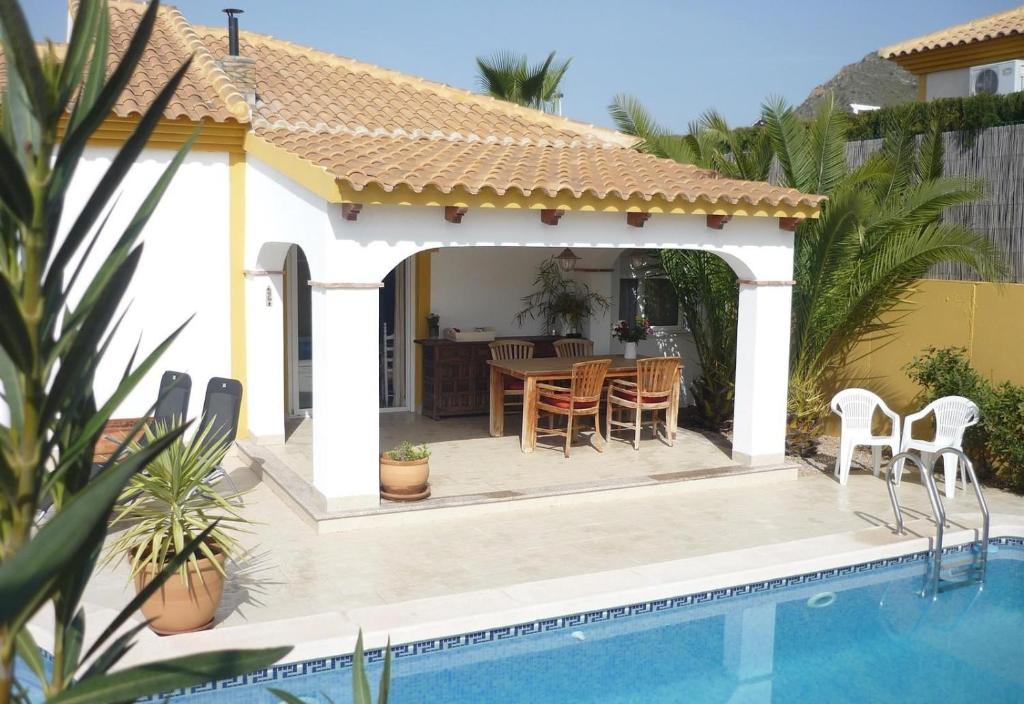 a gazebo with a table and chairs next to a pool at Villa Miantojo in Mazarrón