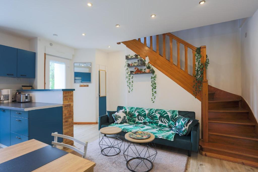 a living room with a couch and a kitchen at Oasis tropicale a Cleguerec in Cléguérec