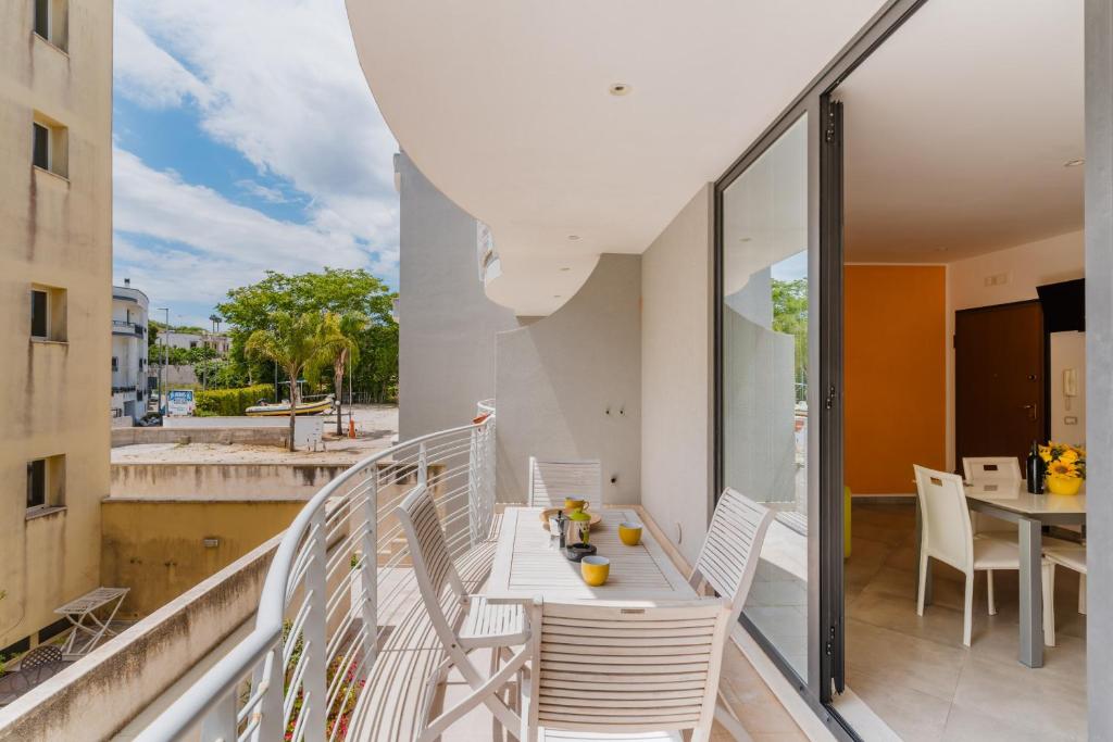 a balcony with white chairs and a table at Casa Vacanza Susanna in Otranto