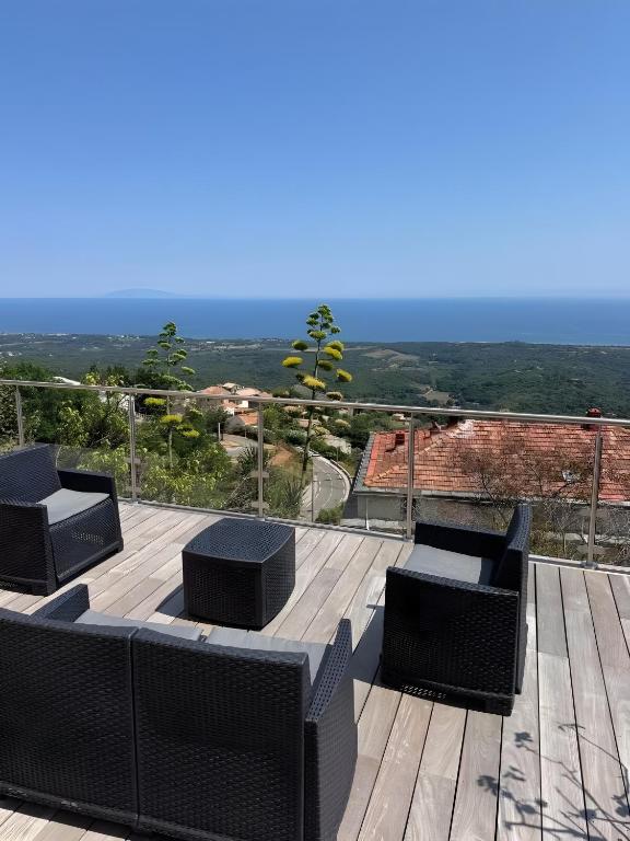 a deck with chairs and a view of the mountains at Maison Corsica vue mer exceptionnel in Cervione