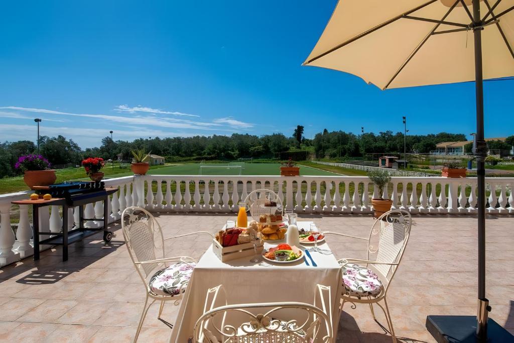 a table and chairs on a patio with an umbrella at Maestro Apartment 2 in Vlachopoulátika