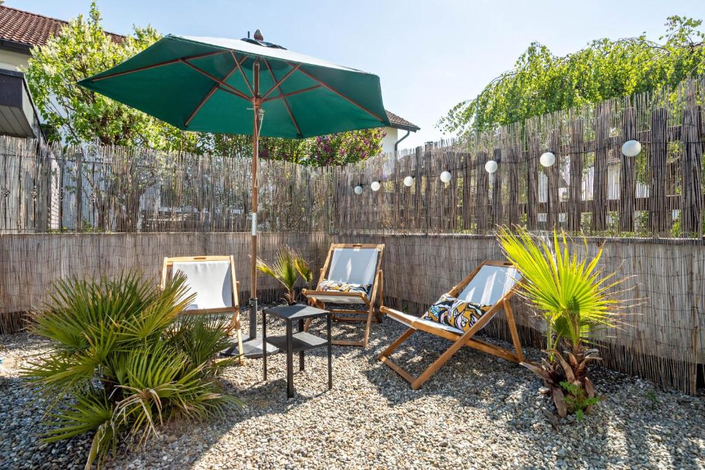 a patio with two chairs and an umbrella at Casa Noho in Nonnenhorn