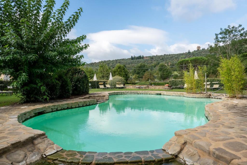 a swimming pool with blue water in a yard at Apartament Monastero in Cortona