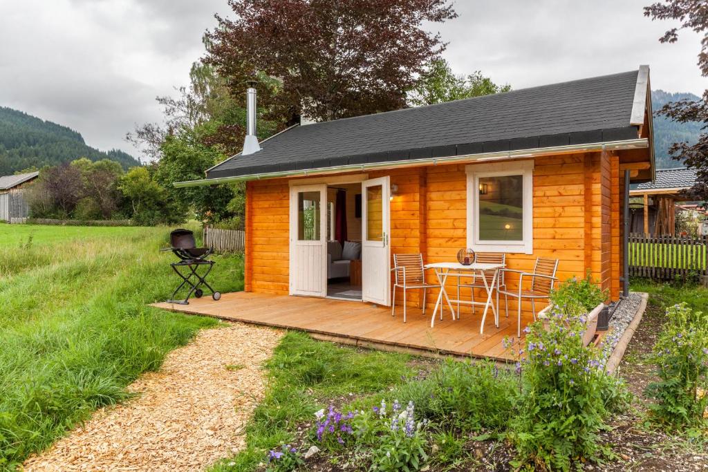 a tiny house with a deck and a table at Sundowner Cabin in Oberammergau