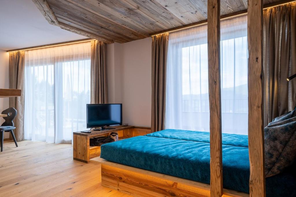 a bedroom with a canopy bed and a television at Ladinser Hof Sternenhimmel in Castelrotto