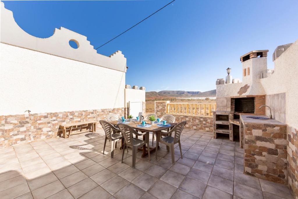 a patio with a table and chairs and a fireplace at La Tierra in Níjar