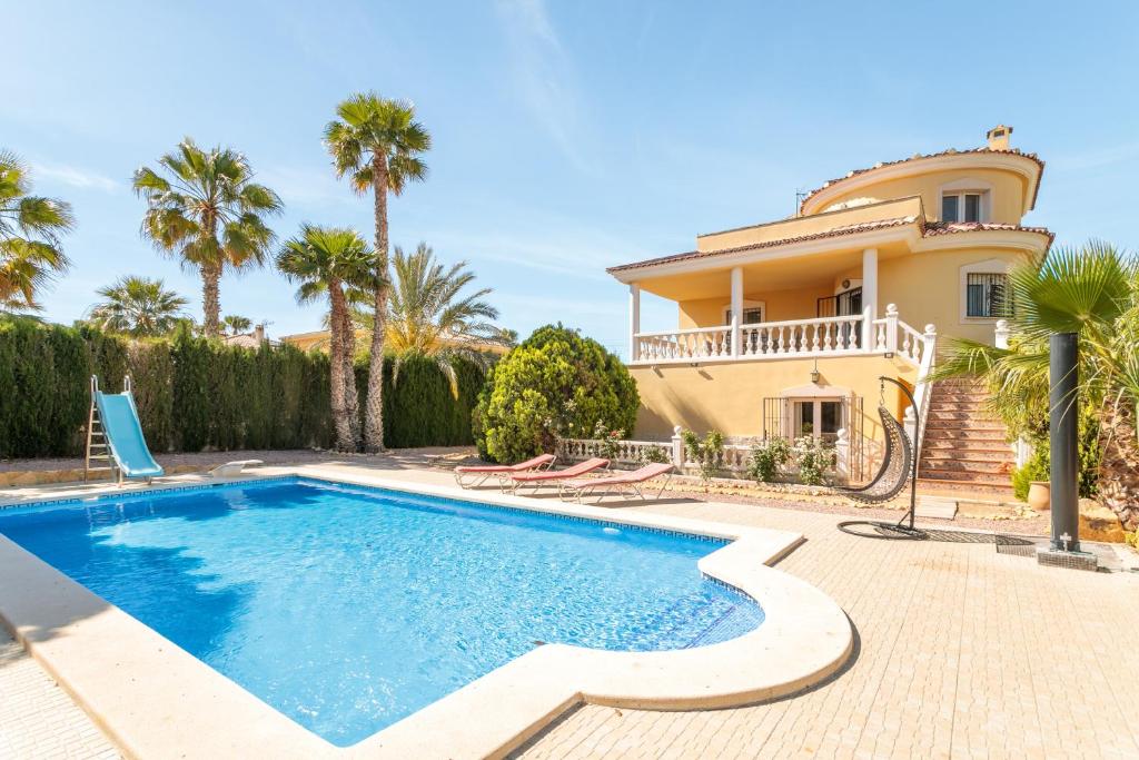 a villa with a swimming pool in front of a house at Chalet Limonita in Mutxamel
