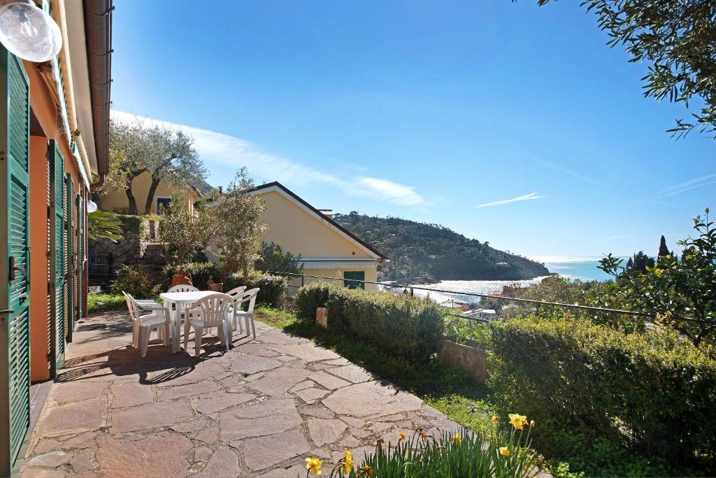 a patio with a table and chairs and a view of the ocean at Villa Del Sole in Bonassola