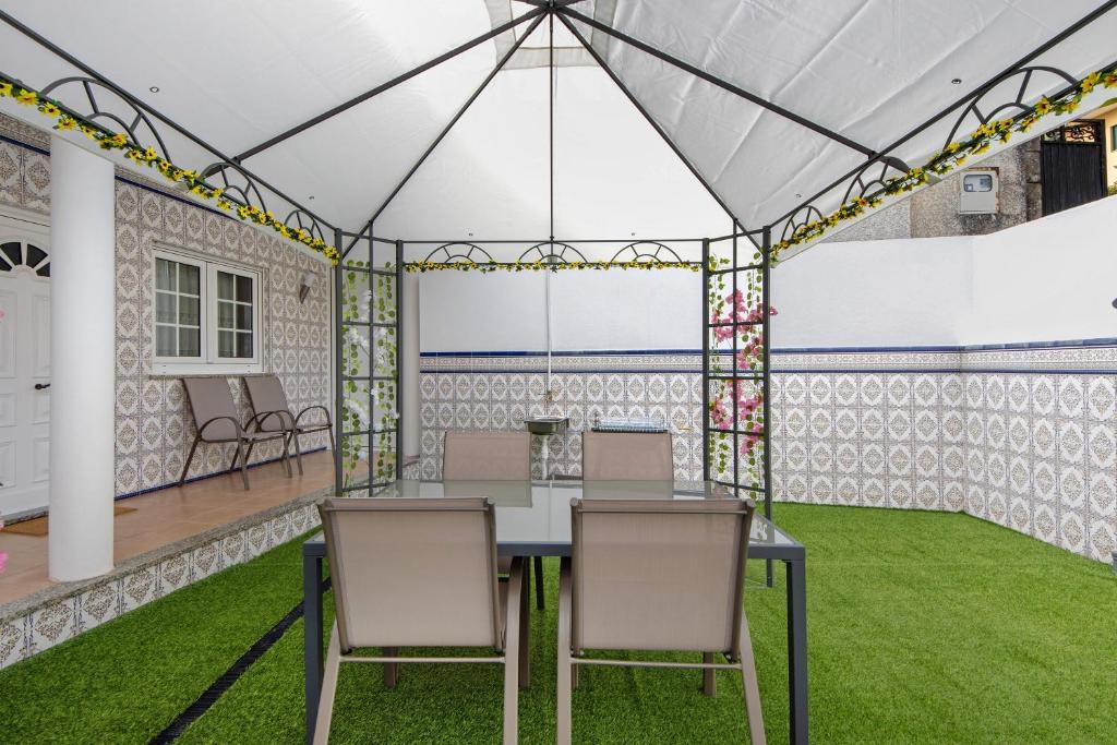 a room with a table and chairs and grass at Casa Cimo D'Aldeia in Vila Cova de Perrinho