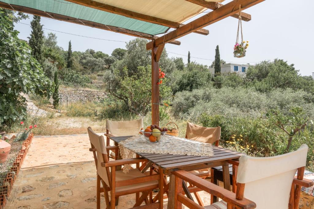 a wooden table and chairs on a patio at Boutique Stone Cottage House in Kalymnos