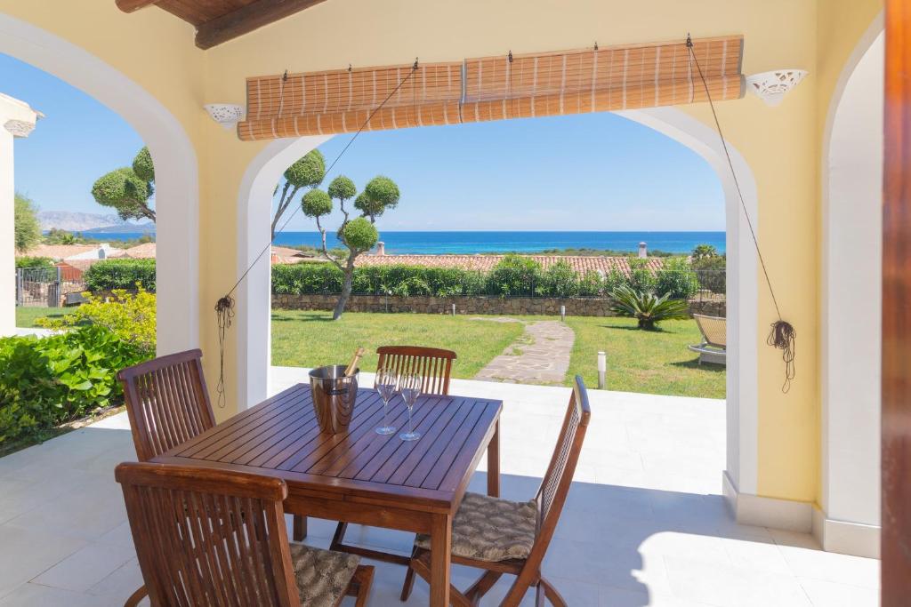a table and chairs on a patio with a view of the ocean at San Teodoro Villa Ambra Costa Caddu in San Teodoro