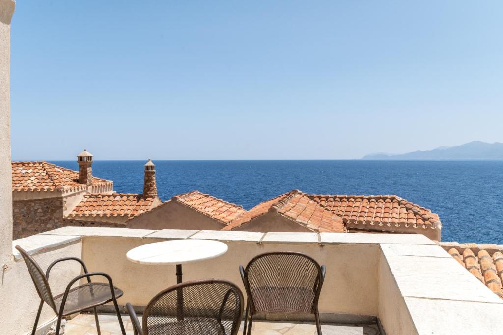 a table and chairs on a balcony overlooking the ocean at Casa Tradizionale Monemvasia in Monemvasia