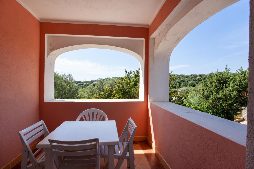 a table and chairs in a room with a window at Appartamento Paguro in Cala Liberotto