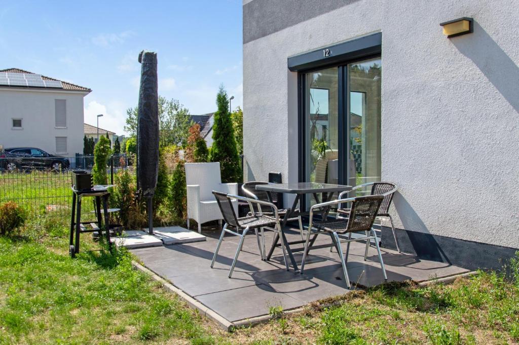 a patio with a table and chairs in a yard at Luxusvilla Neubau 2 in Oberasbach