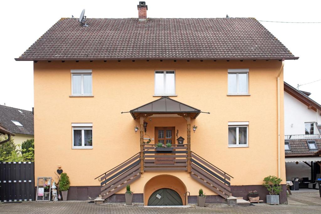a large yellow house with a large staircase at Ferienwohnung Sink in Staufen im Breisgau