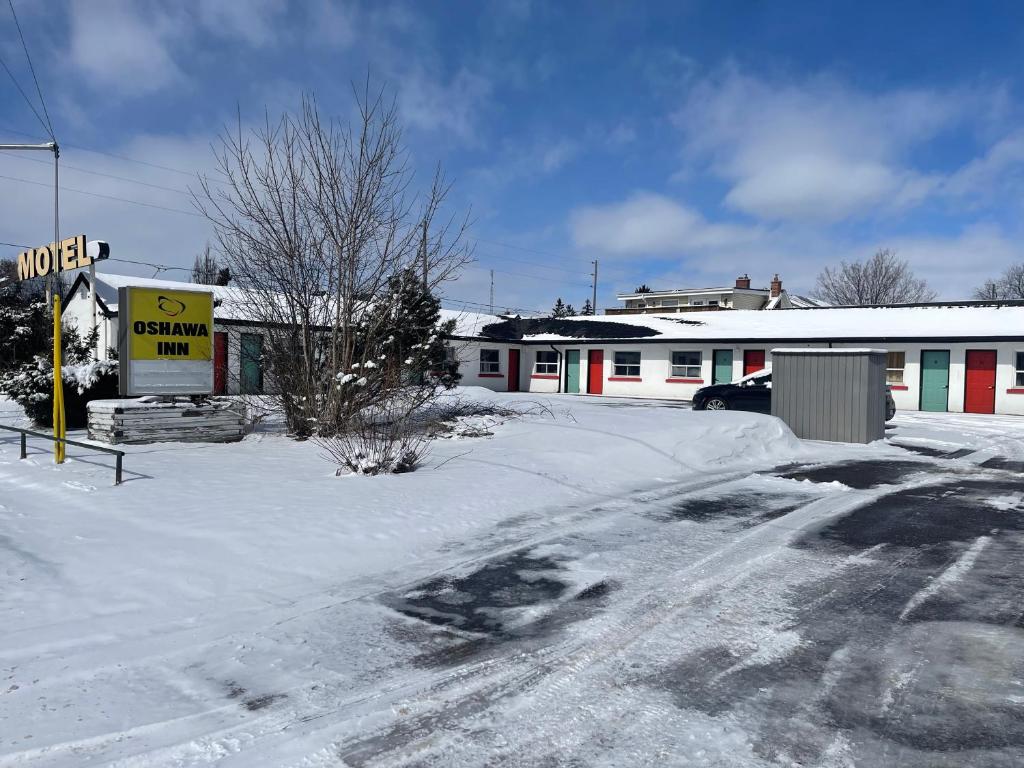 a snow covered street in front of a building at Oshawa Inn Motel in Oshawa