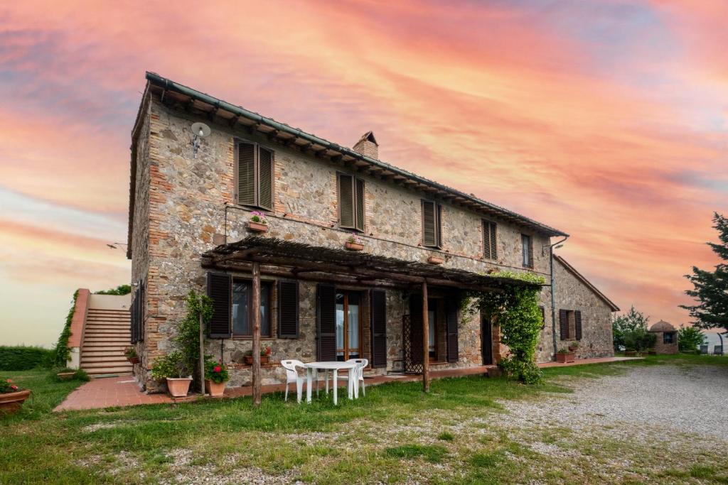 an old stone house with a white table in front of it at Appartamento Geranio in Radicofani