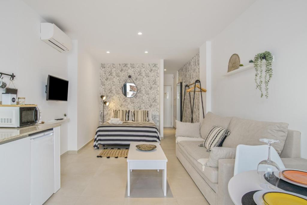 a white living room with a couch and a table at Apartamento Black and White 1 11 in Tarifa