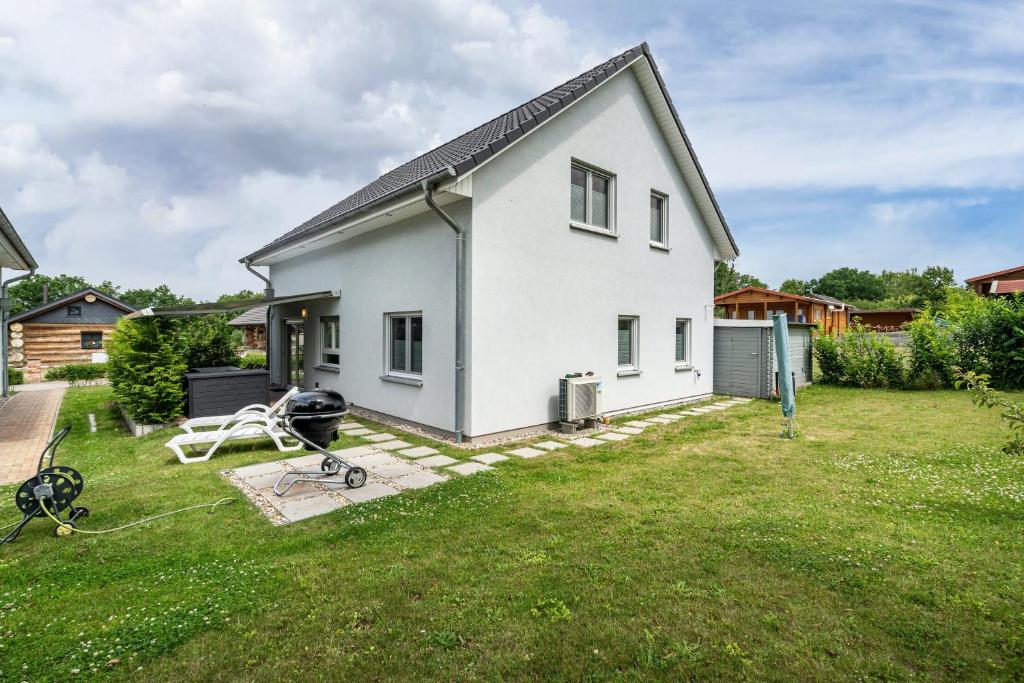 a white house with a large yard with a yard at Seeglück 1 am Tollensesee in Groß Nemerow
