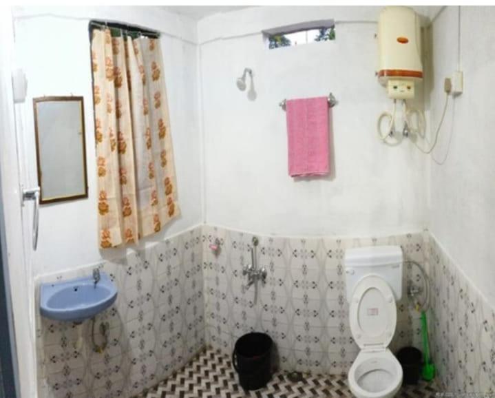 a small bathroom with a toilet and a sink at Andy homestay in Mawlynnong
