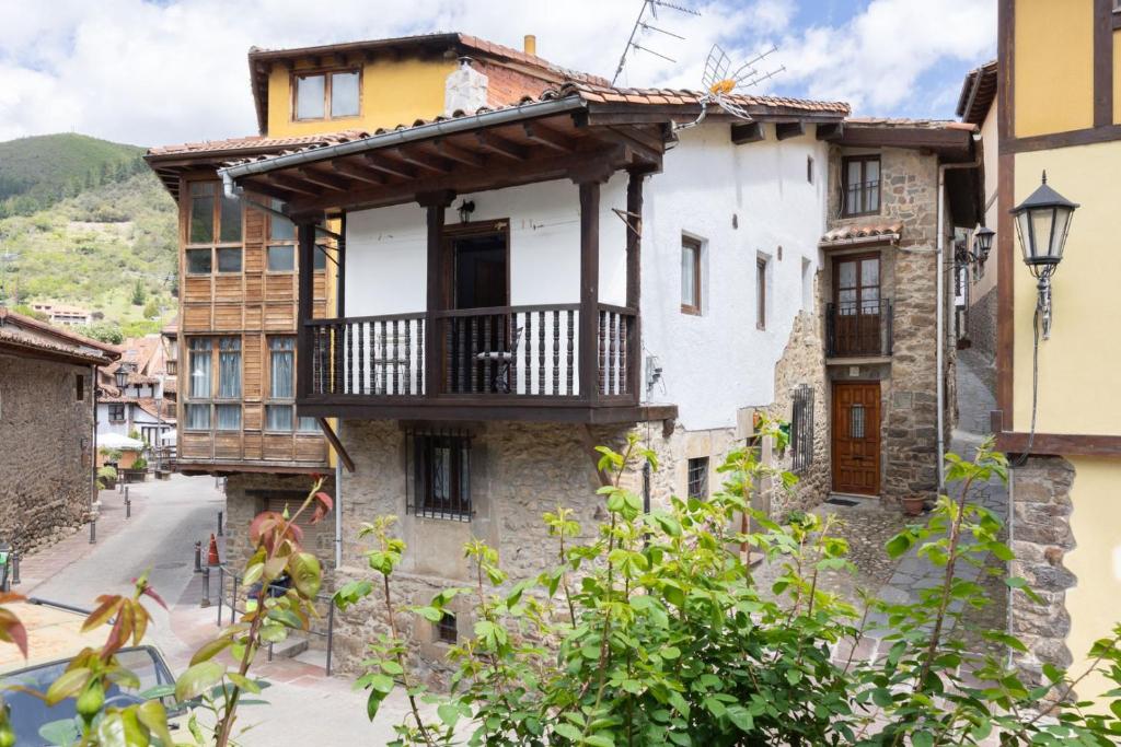 an old house with a balcony on a street at Casa Raymonde in Potes