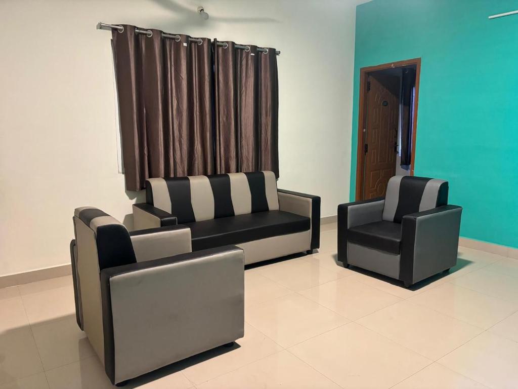 two chairs and a couch in a living room at Thamira Residency Yercaud in Yercaud