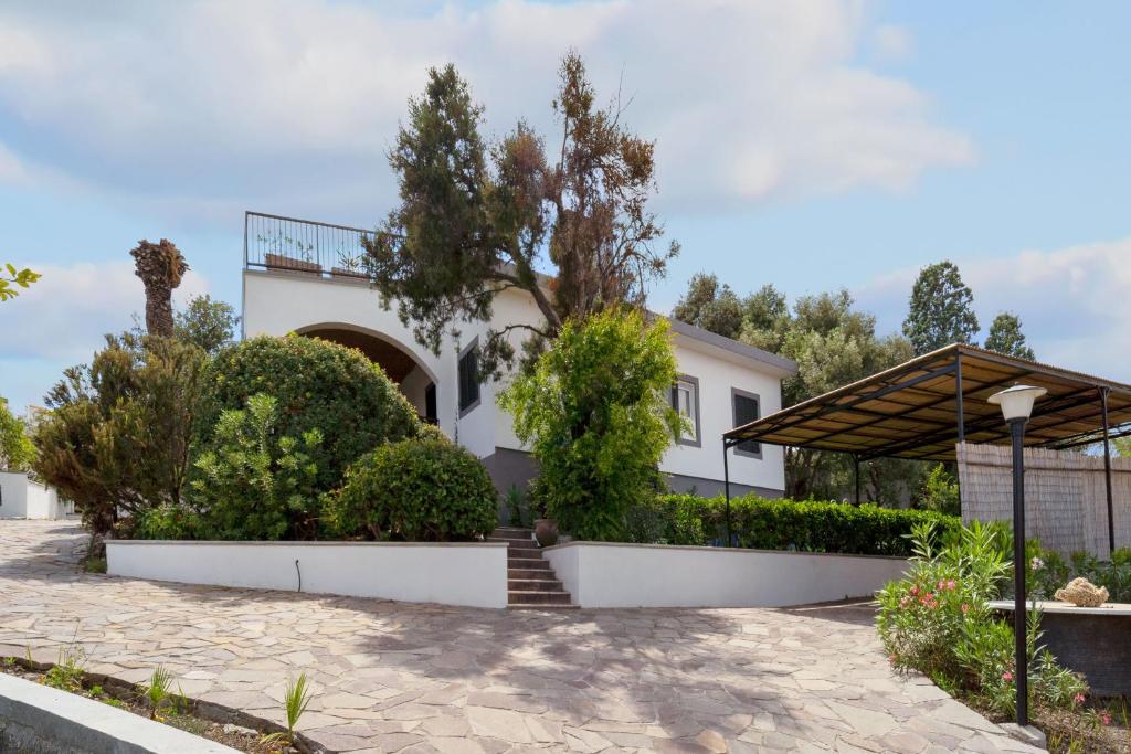 a white house with trees and bushes at Villa Matteo in Porto Columbu - Perdʼe Sali