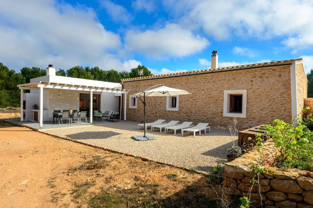 a building with a patio and an umbrella at Can Xumeu Ferrer in La Mola