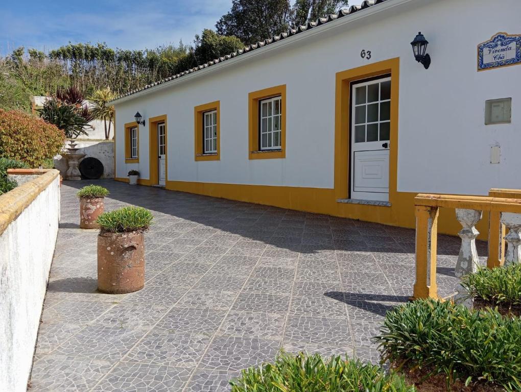 a white and yellow building with a patio at Vivenda Chã in Ribeira Funda