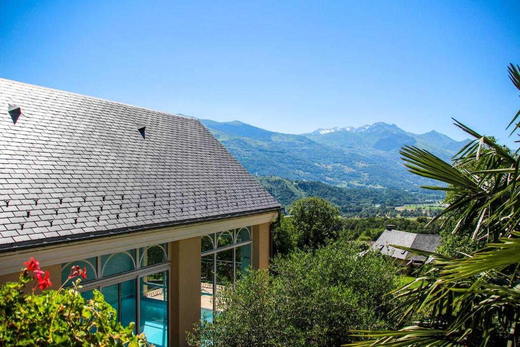 a house with a roof with mountains in the background at Gite Le Bérierot avec piscine in Ouzous