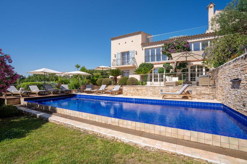 a swimming pool in front of a house at Le Mas d'Aiguebelle in La Croix-Valmer