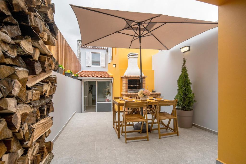 a patio with a table and an umbrella at V L P Amorim in Ponta Delgada