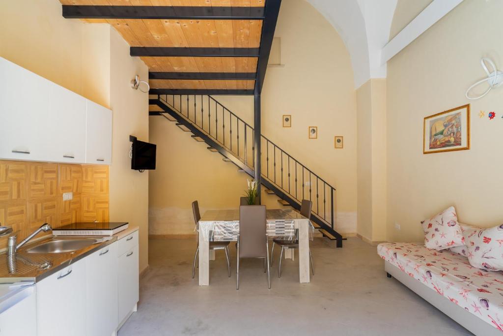 eine Küche und ein Esszimmer mit einem Tisch und einer Treppe in der Unterkunft La rimesa di Tittì - Simone in Alezio