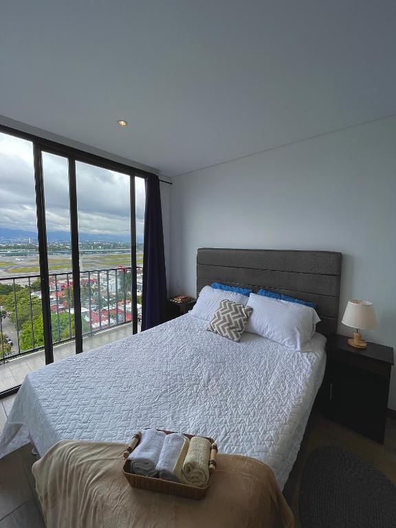 a bedroom with a bed and a large window at Inara 2 - Apartment with airport views - Zona 13 de la Ciudad de Guatemala in Estación Pamplona