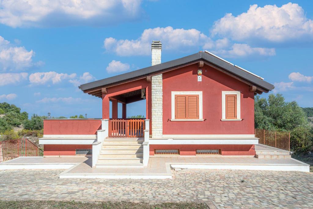 a small red house with a porch at Le colline sul mare in Sortino
