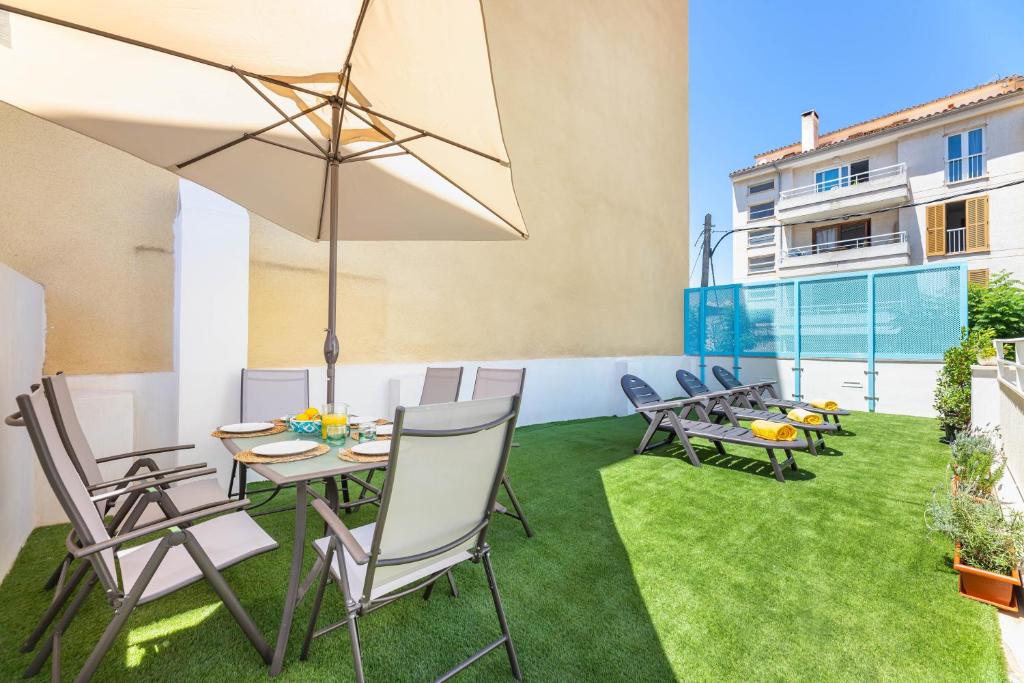 a patio with chairs and tables and an umbrella at Albercutx Pollentia 2 in Port de Pollensa